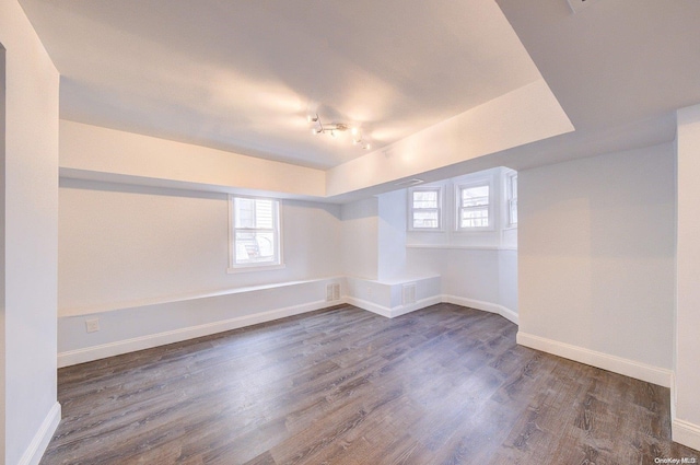 spare room with dark wood-type flooring and a healthy amount of sunlight