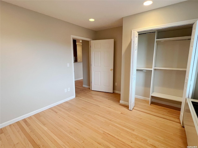 unfurnished bedroom featuring light hardwood / wood-style flooring and a closet