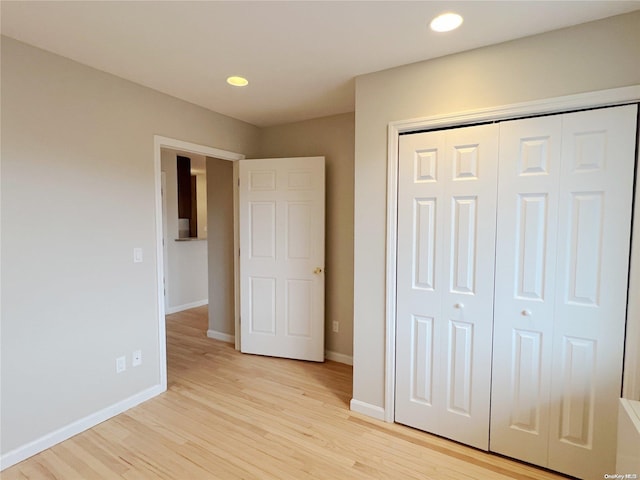 unfurnished bedroom featuring a closet and light hardwood / wood-style flooring