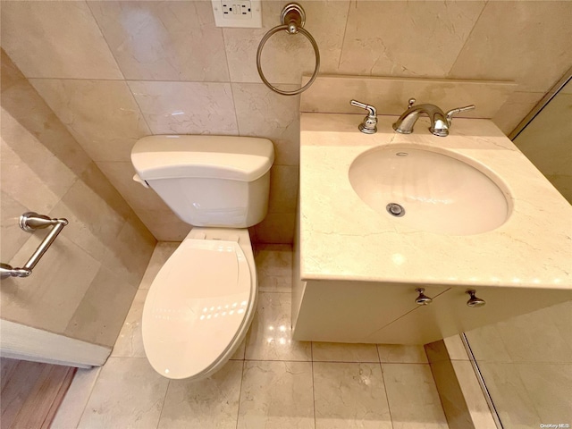 bathroom with vanity, tile walls, and toilet