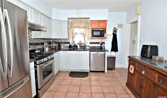 kitchen with backsplash, stainless steel appliances, sink, white cabinets, and light tile patterned flooring