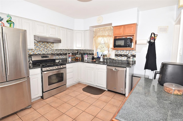 kitchen featuring white cabinets, stainless steel appliances, and tasteful backsplash