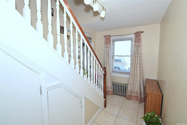 stairway with radiator heating unit and tile patterned flooring