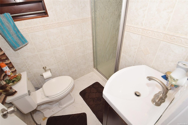 bathroom with sink, tile patterned flooring, toilet, a shower with door, and tile walls