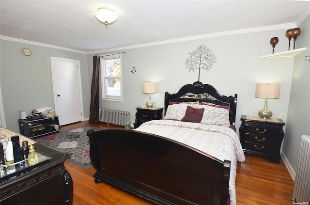 bedroom with hardwood / wood-style flooring, radiator, and ornamental molding