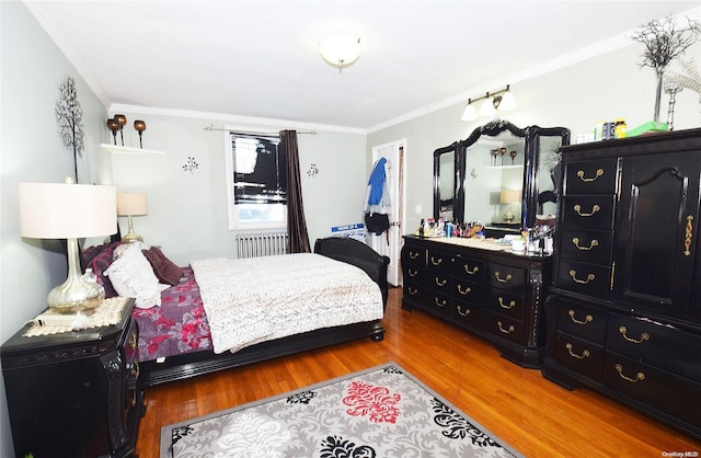 bedroom featuring radiator heating unit, hardwood / wood-style flooring, and crown molding