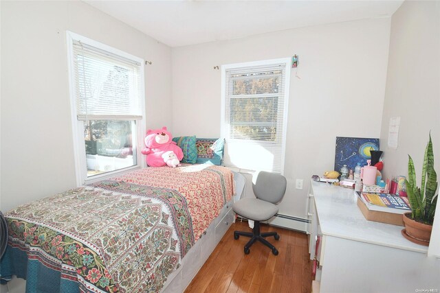 bedroom with light hardwood / wood-style flooring and a baseboard radiator