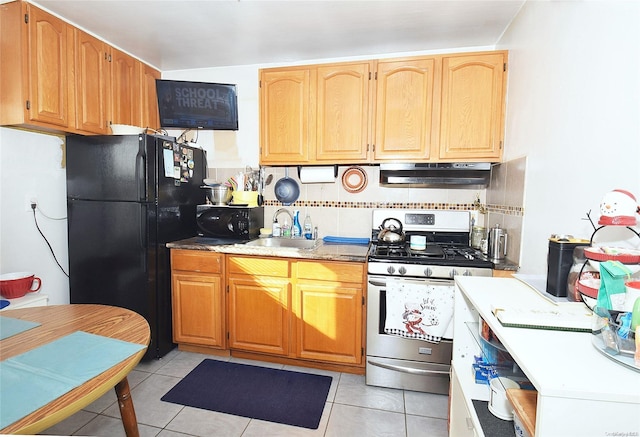 kitchen with tasteful backsplash, light tile patterned floors, and black appliances