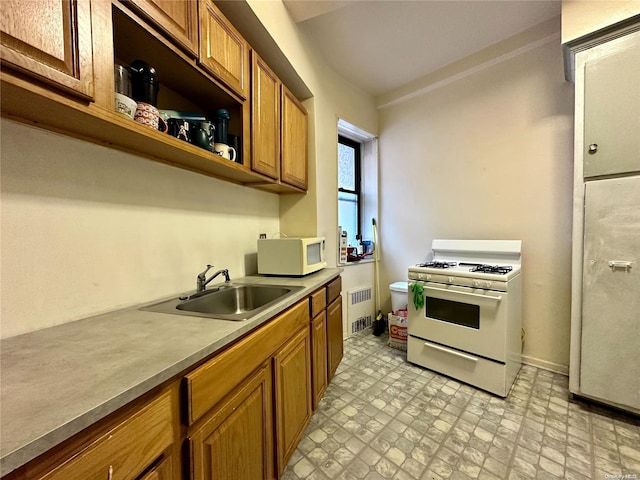 kitchen featuring white appliances, sink, and radiator