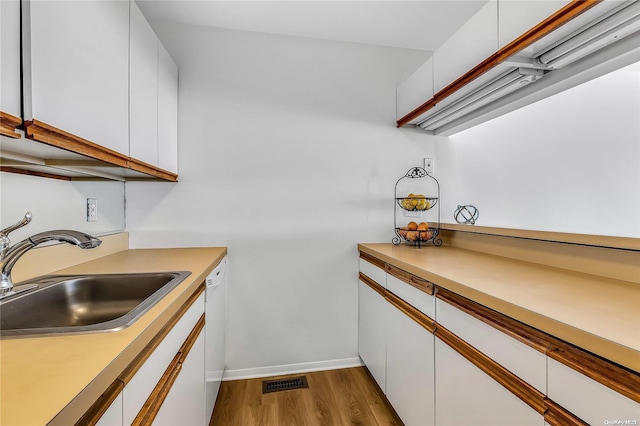 kitchen featuring white cabinets, sink, white dishwasher, and hardwood / wood-style floors