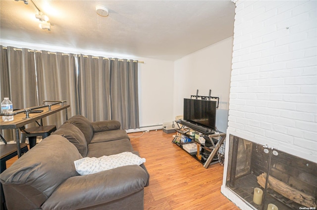 living room with light hardwood / wood-style flooring, rail lighting, a baseboard radiator, and a textured ceiling