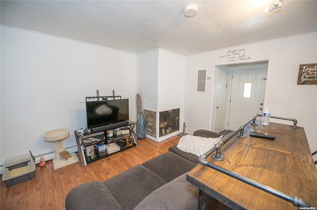 living room with a fireplace, ornamental molding, and hardwood / wood-style flooring