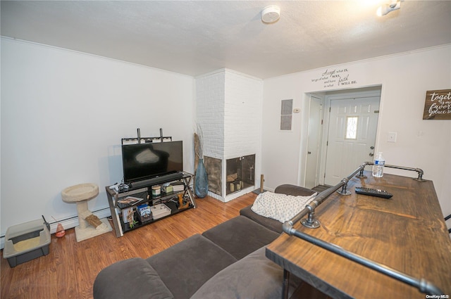 living room with a fireplace, a textured ceiling, hardwood / wood-style flooring, and crown molding