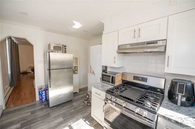 kitchen featuring white cabinetry, wood-type flooring, light stone countertops, and stainless steel appliances