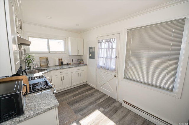 31 William St, Copiague, NY 11726 - kitchen with a baseboard heating unit, crown molding, under cabinet range hood, white cabinets, and dark wood finished floors