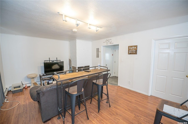 interior space featuring hardwood / wood-style floors, rail lighting, and a textured ceiling