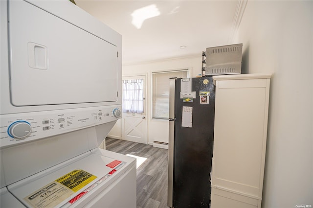 washroom featuring stacked washer / drying machine, crown molding, dark wood-type flooring, and a baseboard radiator