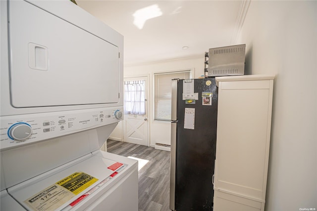 31 William St, Copiague, NY 11726 - washroom featuring stacked washer / drying machine, wood finished floors, and a baseboard heating unit