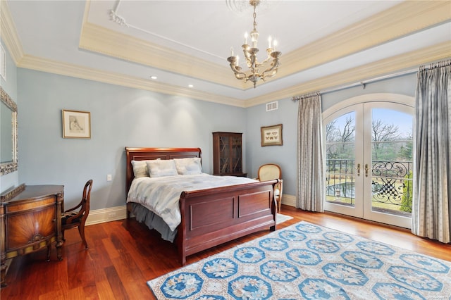 bedroom with dark wood-type flooring, french doors, a raised ceiling, access to exterior, and ornamental molding