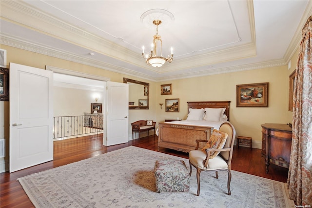 bedroom featuring a raised ceiling, crown molding, dark wood-type flooring, and an inviting chandelier