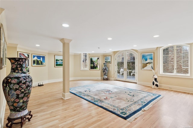 workout area with french doors, light hardwood / wood-style flooring, and crown molding