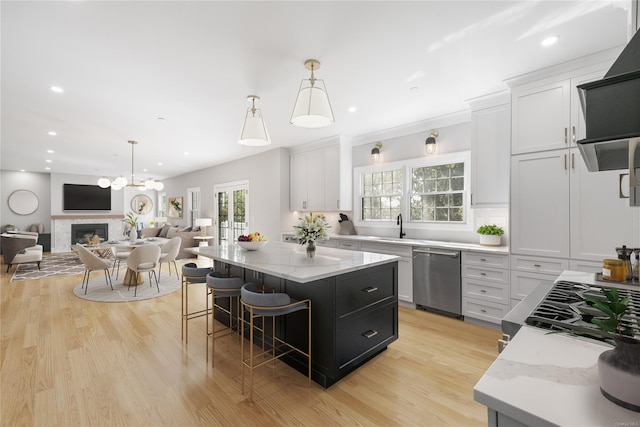 kitchen with stainless steel appliances, hanging light fixtures, a center island, and white cabinets