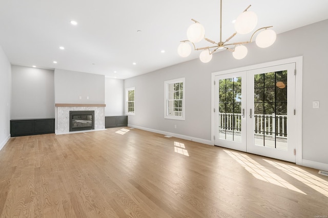 unfurnished living room featuring french doors, light wood-type flooring, and a wealth of natural light