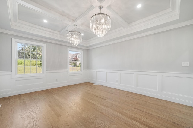 spare room featuring coffered ceiling, a notable chandelier, ornamental molding, light hardwood / wood-style floors, and beamed ceiling