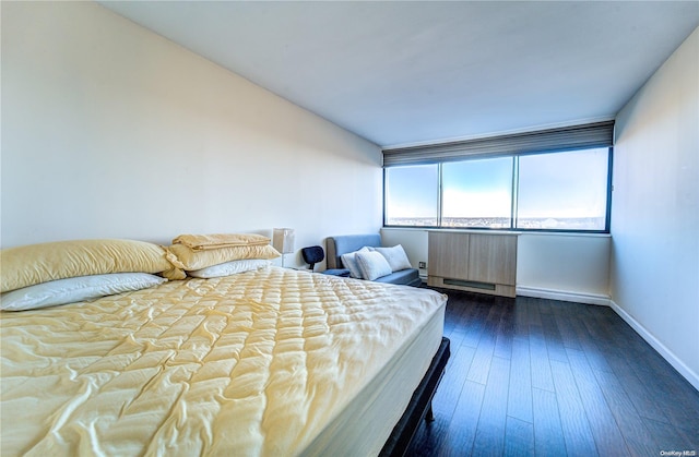 bedroom with radiator heating unit and dark hardwood / wood-style floors