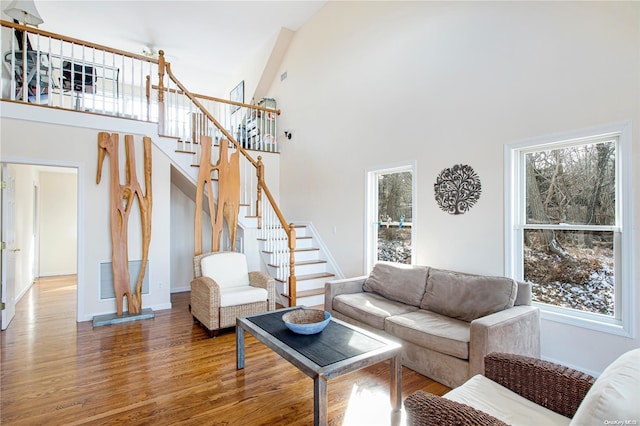 living room featuring hardwood / wood-style flooring, plenty of natural light, and high vaulted ceiling