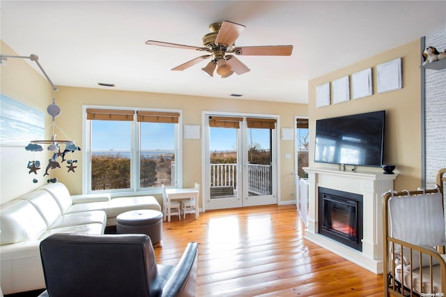 living room featuring ceiling fan and light hardwood / wood-style floors