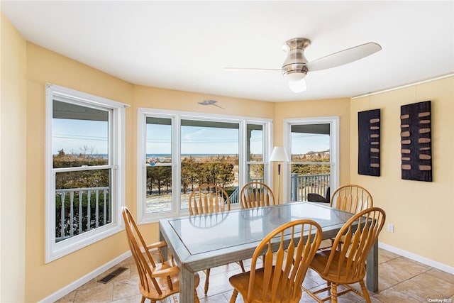 tiled dining area with ceiling fan