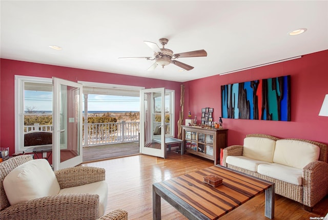 living room with hardwood / wood-style floors, ceiling fan, and french doors