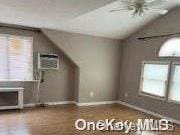 additional living space with ceiling fan, a wall mounted air conditioner, and lofted ceiling