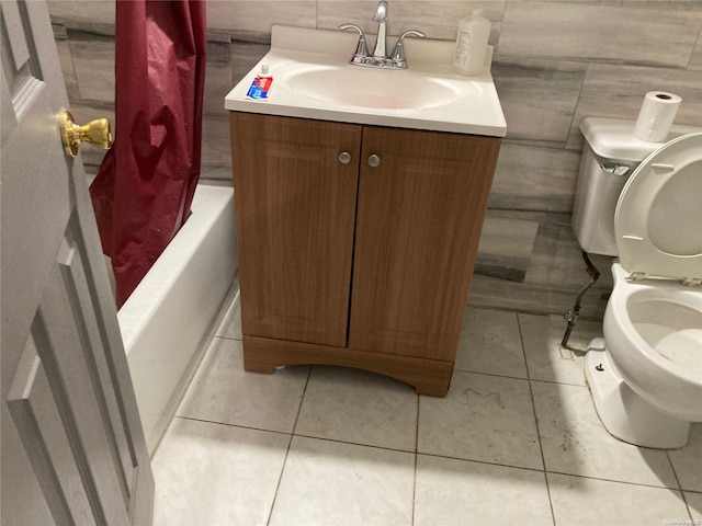 bathroom with tile patterned floors, vanity, toilet, and tile walls