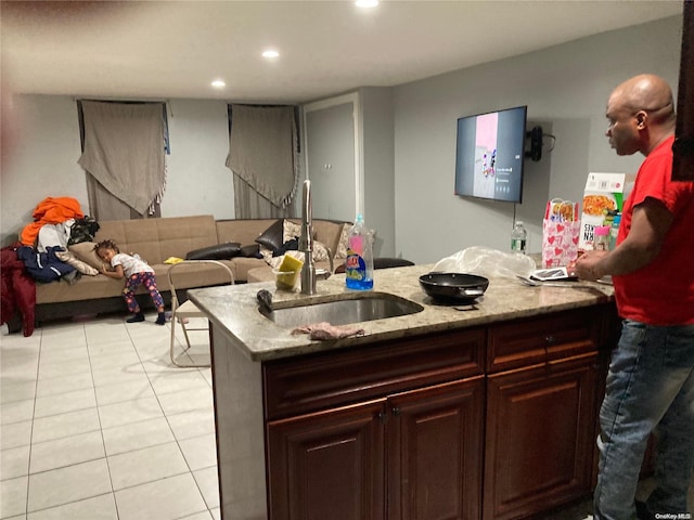 kitchen with light stone countertops, light tile patterned floors, and sink