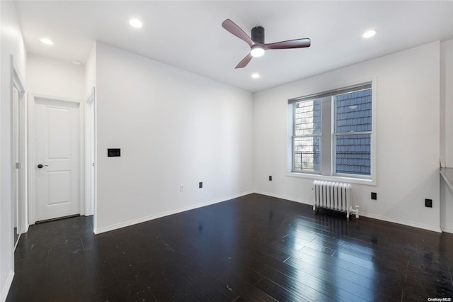 unfurnished room featuring dark hardwood / wood-style floors, radiator, and ceiling fan