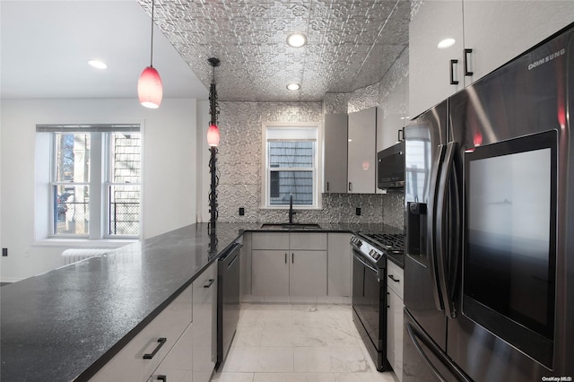 kitchen with decorative backsplash, sink, black appliances, pendant lighting, and gray cabinets