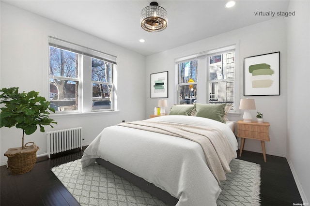 bedroom with radiator heating unit and dark hardwood / wood-style floors