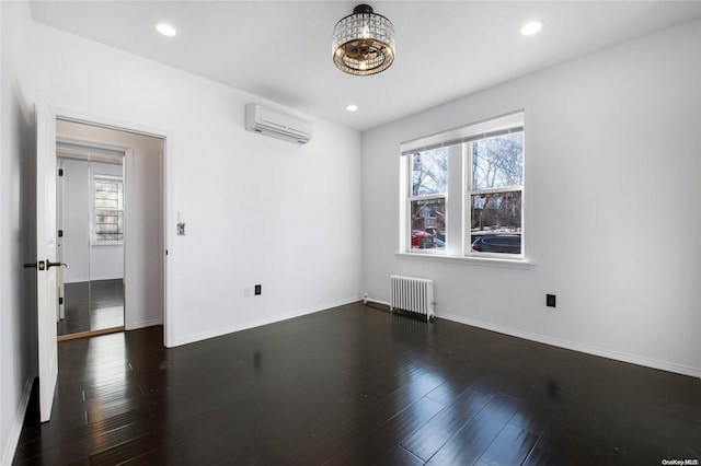 unfurnished room featuring dark hardwood / wood-style flooring, plenty of natural light, radiator, and an AC wall unit