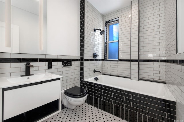 full bathroom featuring tiled shower / bath combo, tile patterned flooring, toilet, vanity, and tile walls