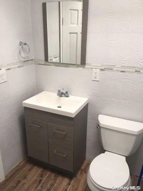 bathroom featuring hardwood / wood-style floors, vanity, and toilet