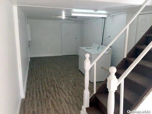 basement with washing machine and clothes dryer and dark hardwood / wood-style floors