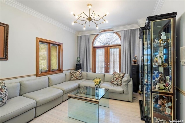 living room featuring an inviting chandelier, french doors, ornamental molding, and light hardwood / wood-style flooring