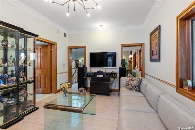 living room with crown molding, light hardwood / wood-style flooring, and a notable chandelier