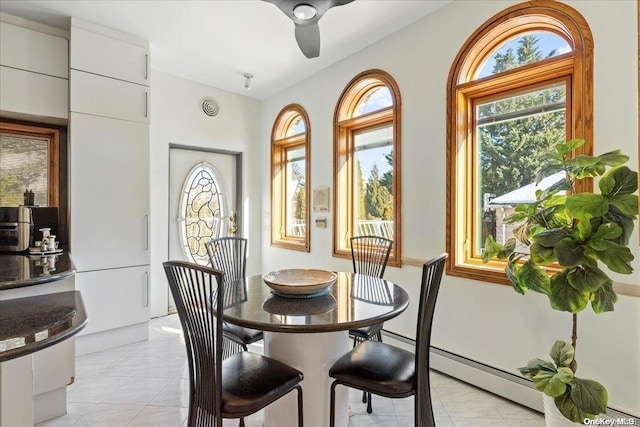 tiled dining space featuring baseboard heating and ceiling fan