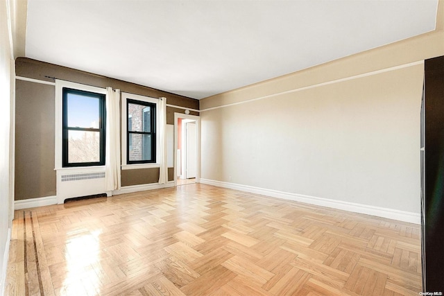 spare room with light parquet flooring and radiator