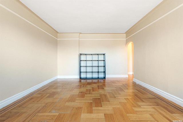 empty room featuring crown molding and light parquet flooring