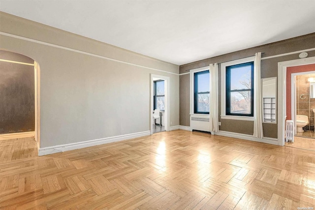 unfurnished room featuring radiator heating unit and light parquet flooring