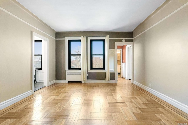 empty room with radiator heating unit and light parquet flooring